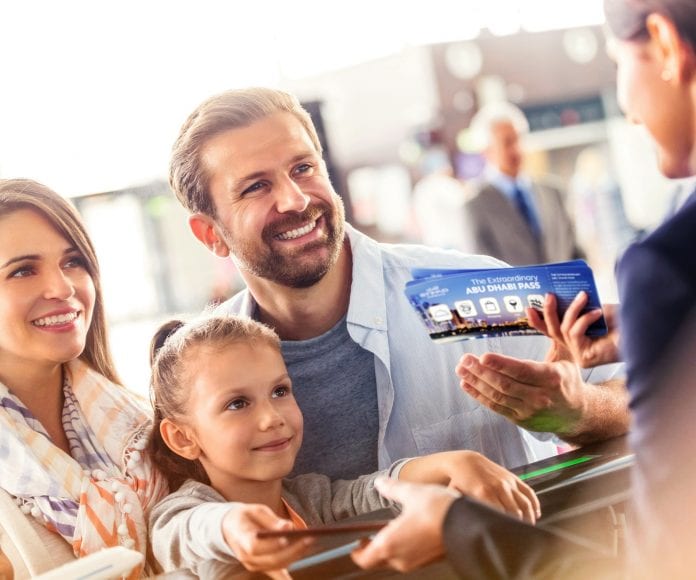 Customer service representative helping family with tickets at airport check-in counter