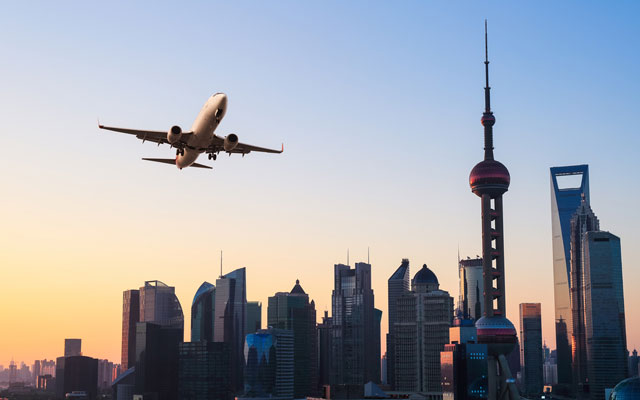 shanghai-modern-buildings-skyline-with-airplane-in-sunrise