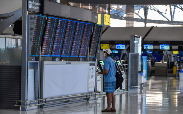 lonely-passenger-wear-protective-face-mask-check-departure-flight-schedule-at-empty-Bangkok-International-Airport-during-COVID-19-in-February-2021